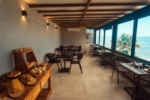 a restaurant with tables and chairs and a view of the ocean at Marilyn Pousada Morro in Morro de São Paulo