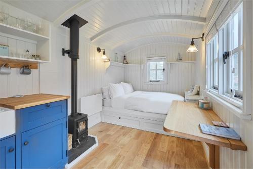 a small bedroom with a bed and a stove at Host & Stay - The Lobster Pot in Saltburn-by-the-Sea