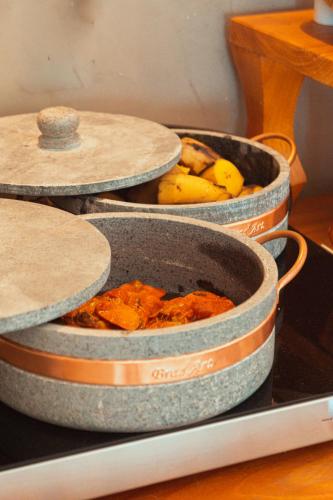 three pans of food sitting on a table with bananas at Marilyn Pousada Morro in Morro de São Paulo