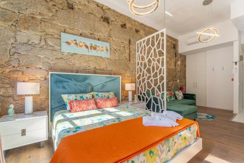 a bedroom with a bed and a stone wall at Apartamento Qian porto Centro 2 in Porto