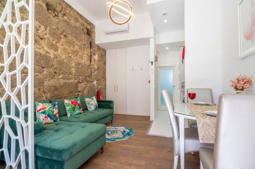 a living room with a green couch and a table at Apartamento Qian porto Centro 2 in Porto