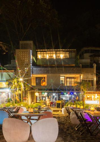 a group of tables and chairs on the beach at night at Marilyn Pousada Morro in Morro de São Paulo