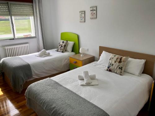 a bedroom with two beds with towels on them at Piso Ribeira Sacra in Monforte de Lemos