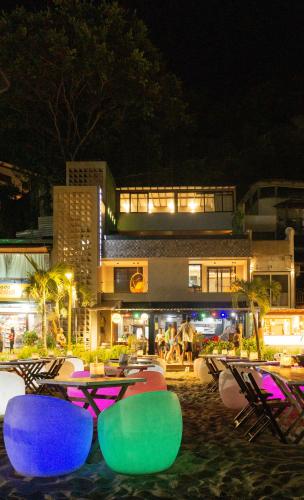 a group of tables and chairs on a beach at night at Marilyn Pousada Morro in Morro de São Paulo