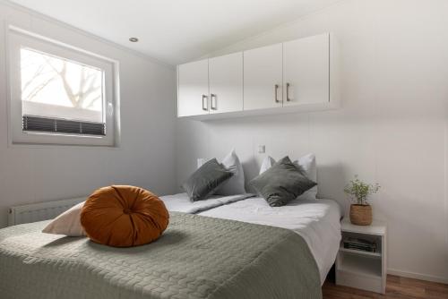 een slaapkamer met 2 bedden en een pompoen op het bed bij Vakantiepark Klein Vink - Boulevard 27 in Arcen