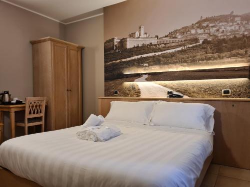 a bedroom with a bed with a painting on the wall at Hotel Cladan in Assisi