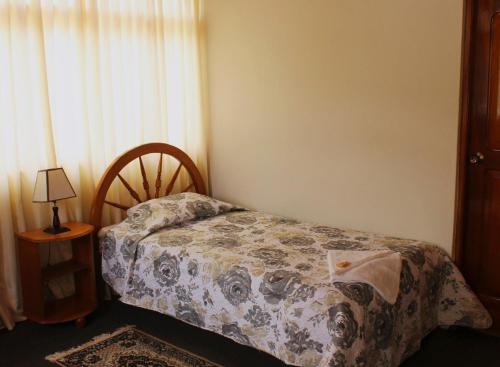 a small bedroom with a bed and a window at Schmidt Hostal in Pozuzo