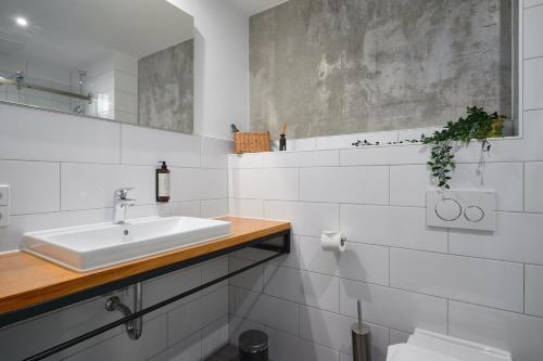 a white bathroom with a sink and a mirror at Stylisches Studio im Herzen Leipzigs in Leipzig