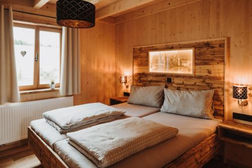 a bed in a room with a wooden wall at Oberwald Chalets Ferienhaus 2 in Breungeshain
