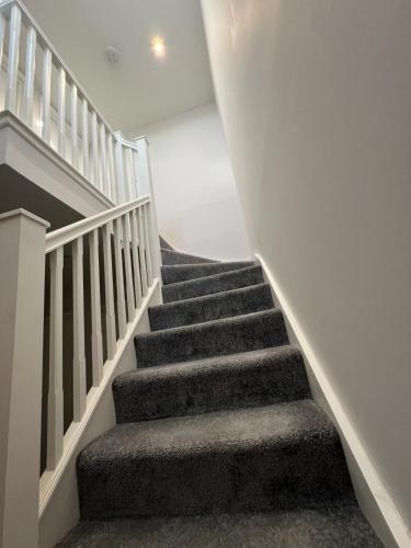 una escalera en una casa con alfombra gris en Beautiful Shared One Bed Flat (Room/Front) en Strood