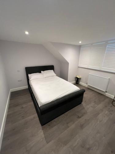 a bedroom with a large bed with white sheets at Beautiful Shared One Bed Flat (Room/Front) in Strood