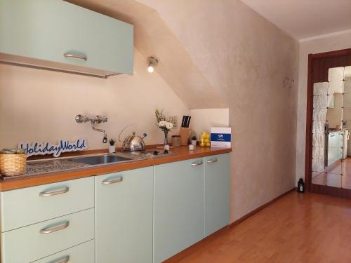 a kitchen with white cabinets and a sink at House Fiocco di Neve by Holiday World in Limone Piemonte