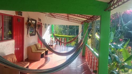 a porch with a hammock in a house at Finca Hotel Spa Zhay in Guateque