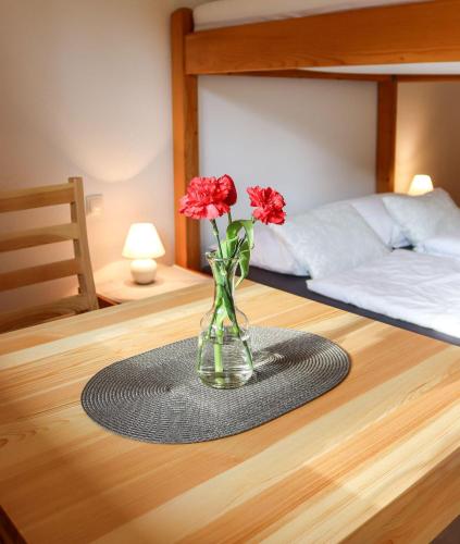 a vase with red flowers on a table in a bedroom at Apartment Vordermitterast in Kirchberg in Tirol