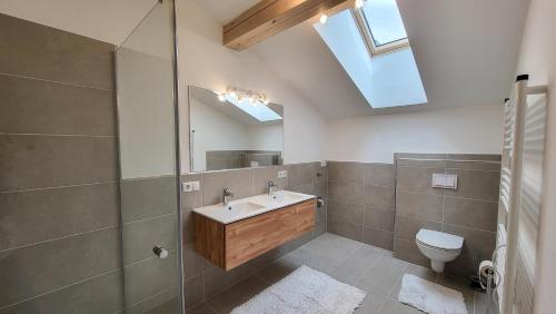 a bathroom with a sink and a toilet and a skylight at Apartment Vordermitterast in Kirchberg in Tirol