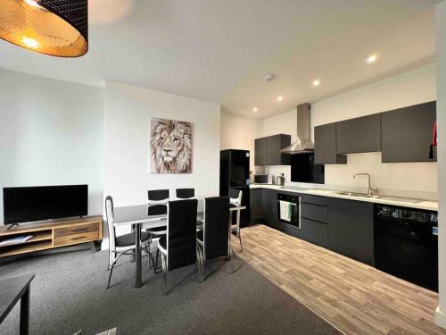 a kitchen with a table and chairs in a room at FREE PARKING - Cosy 2-BR Flat near Salford Royal in Manchester