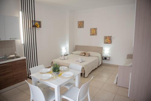 a living room with a bed and a table and chairs at Zagara Holiday House in Siculiana