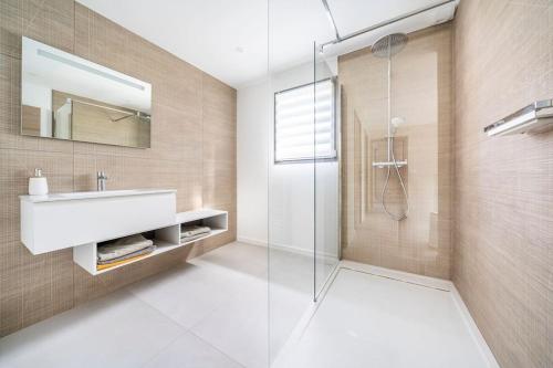 ein Bad mit einem Waschbecken und einer Glasdusche in der Unterkunft Villa L, Vue mer, plage 10 min à pied in Sainte-Maxime