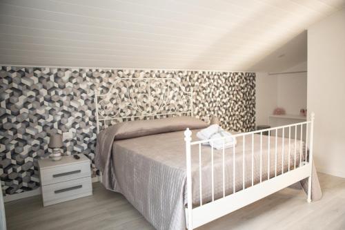 a bedroom with a white bed and a wooden floor at Sweet in Gragnano
