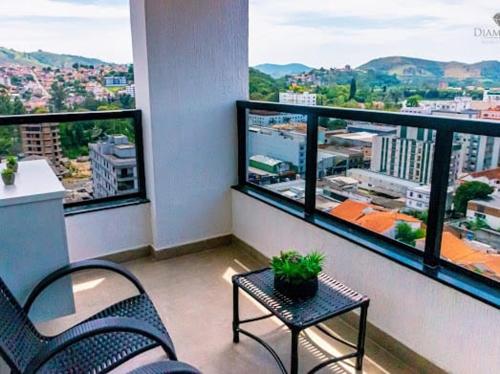 einen Balkon mit 2 Stühlen, einem Tisch und Aussicht in der Unterkunft Diamond Hotéis e Flats in São Lourenço