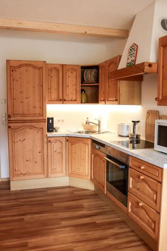a kitchen with wooden cabinets and a stove top oven at Apartment Vordermitterast in Kirchberg in Tirol