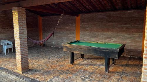 a pool table in a patio with a hammock at Pousada das Cores in Olímpia