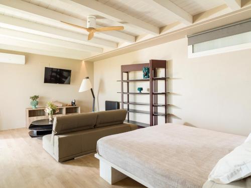 ein Schlafzimmer mit einem Bett und einer Couch in der Unterkunft Agua Green Resort in Reitani