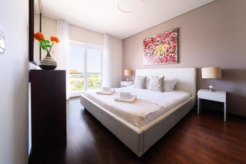Un dormitorio con una gran cama blanca y una ventana en Luxury Apartments Baleal en Baleal