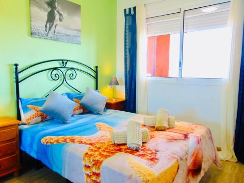 1 dormitorio con cama con sábanas azules y ventana en Casita La Caleta Fuerteventura, en Parque Holandes