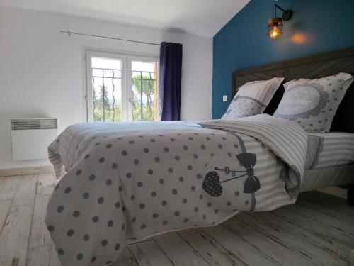 a bedroom with a bed with polka dot bedding at Le temps d'une pause in Villes-sur-Auzon