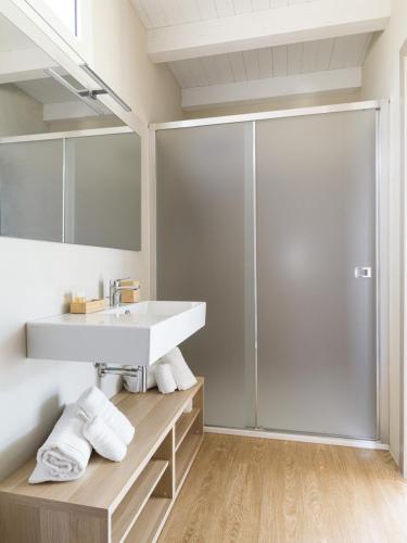 ein Badezimmer mit weißem Waschbecken und Dusche in der Unterkunft Agua Green Resort in Reitani