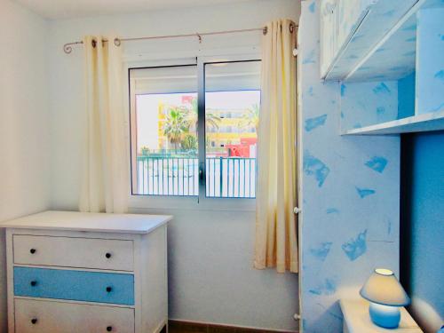 1 dormitorio con 1 cama, vestidor y ventana en Casita La Caleta Fuerteventura, en Parque Holandes