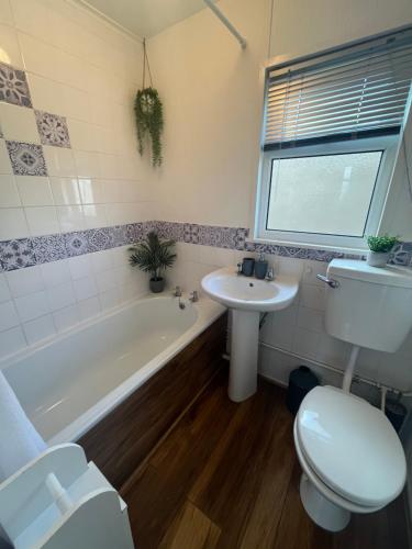 a bathroom with a toilet and a sink and a tub at 159, Two bed Chalet on Sunbeach Holiday Park - Sleeps 5, pet friendly - Onsite entertainment, SWIMMING PASSES INCLUDED - plus WiFi, bed linen and towels included - only 300m from the beach! in Scratby