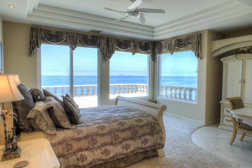 a bedroom with a bed with a view of the ocean at La Mansión Residency Suites Ensenada in Ensenada