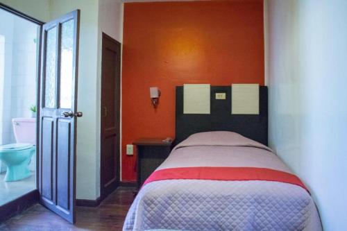 a bedroom with a bed with an orange wall at Skyline in La Paz