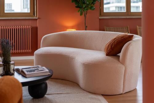 einen weißen Stuhl im Wohnzimmer mit einem Tisch in der Unterkunft The Charming by Curt Suites in Berlin