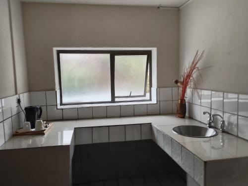 a bathroom with a sink and a window at Naldorado Executive Villa in Nelspruit