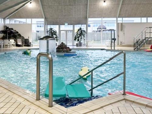 een groot zwembad met stoelen in een gebouw bij Holiday Home Kronvildtvej IV in Brovst