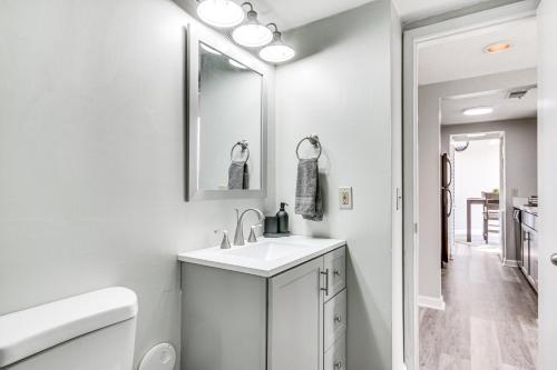 a white bathroom with a sink and a mirror at Columbia Vacation Rental - Walk to UofSC Campus! in Columbia