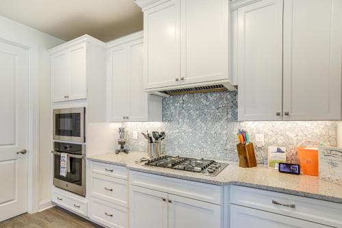 a white kitchen with white cabinets and a stove at Ocean View Home with Kayaks about 2 Mi to Bethany Beach in Ocean View