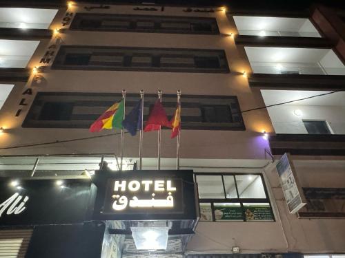 znak hotelowy z flagami wiszącymi na budynku w obiekcie Hotel Ahmed Ali w mieście Dakhla