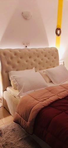 1 dormitorio con 1 cama grande con almohadas blancas en 2 pièces très moderne à Cocody Angré Château, en Cocody