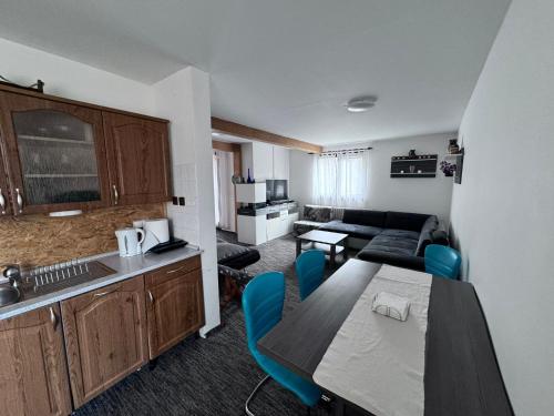 a kitchen and a living room with a table and chairs at Prášily 100 - apartmány in Prášily