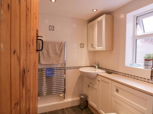 uma casa de banho com um lavatório, um WC e uma janela. em 3 Canada Cottages em Ipswich