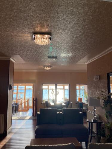 a living room with a couch and a chandelier at Myrtle Bank Hotel in Gairloch