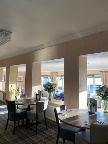 a dining room with tables and chairs and mirrors at Myrtle Bank Hotel in Gairloch