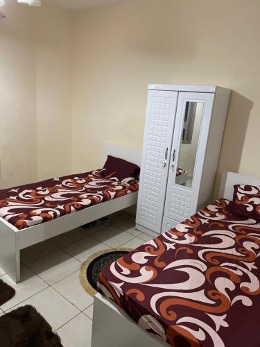 1 dormitorio con 2 camas y espejo en برج المحطة, en Sharjah