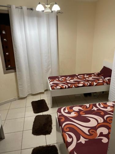 a room with two beds and two rugs at برج المحطة in Sharjah