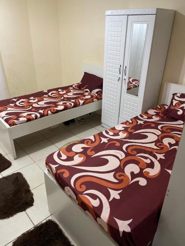 a bedroom with two beds and a mirror at برج المحطة in Sharjah