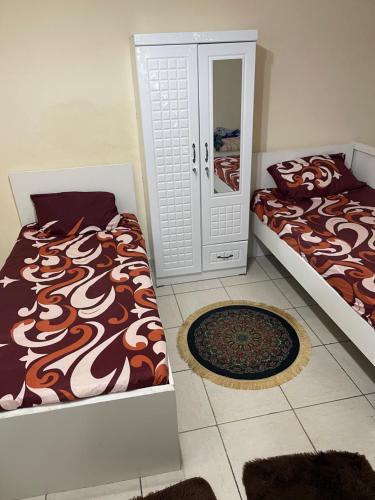 a bedroom with two beds and a mirror at برج المحطة in Sharjah